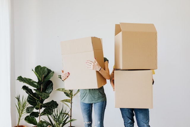 two-tenants-holding-cardboard-boxes-moving-into-rental-unit